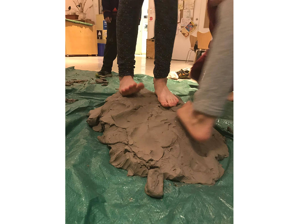 Feet squishing into wet clay.