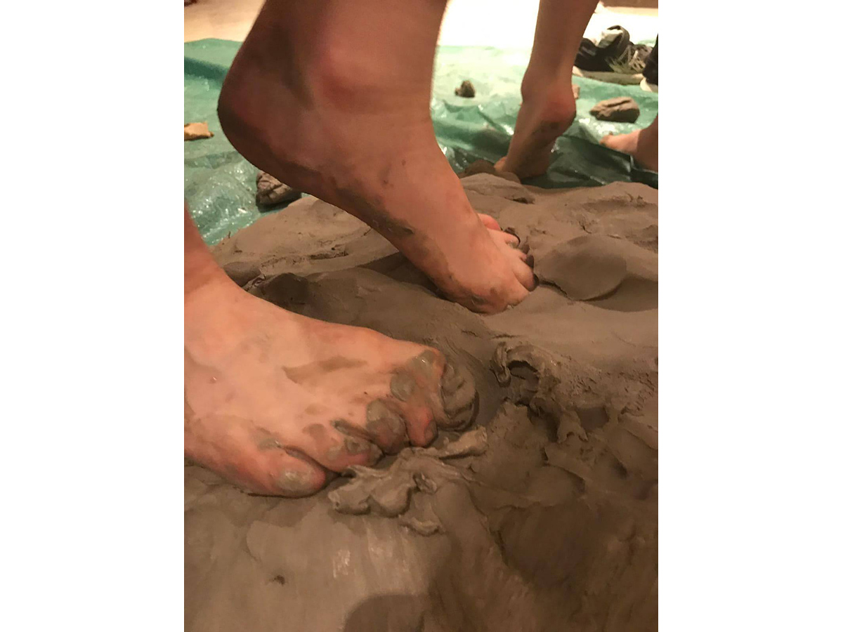 Feet squishing into wet clay.