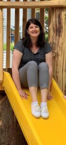 A Photo of Trish on a yellow playground slide